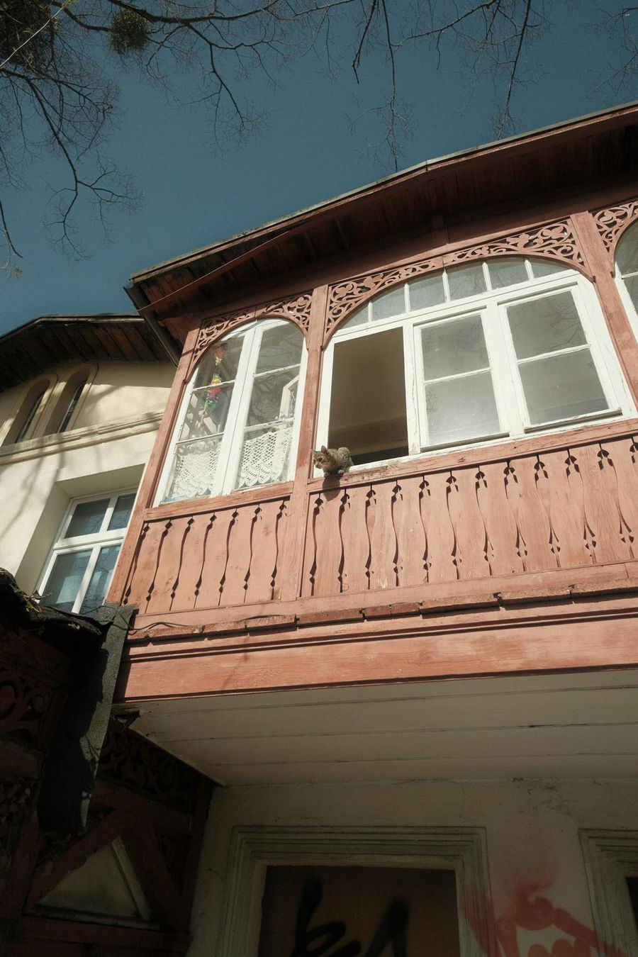 Drewniany rzeźbiony balkon starej sopockiej kamienicy z dużymi oknami